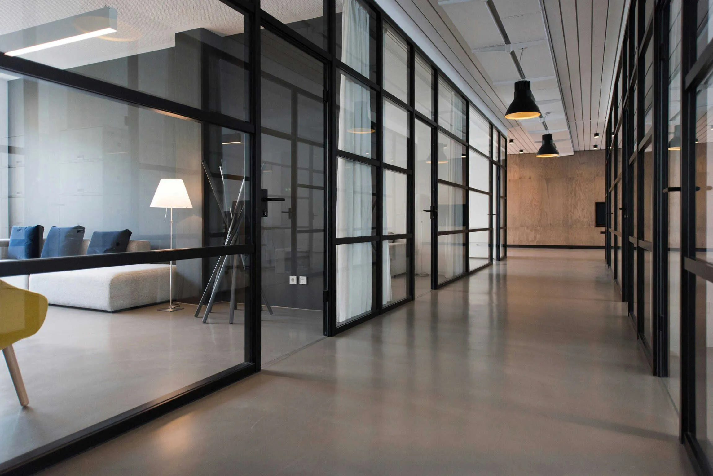 Bright office corridor with glass walls.