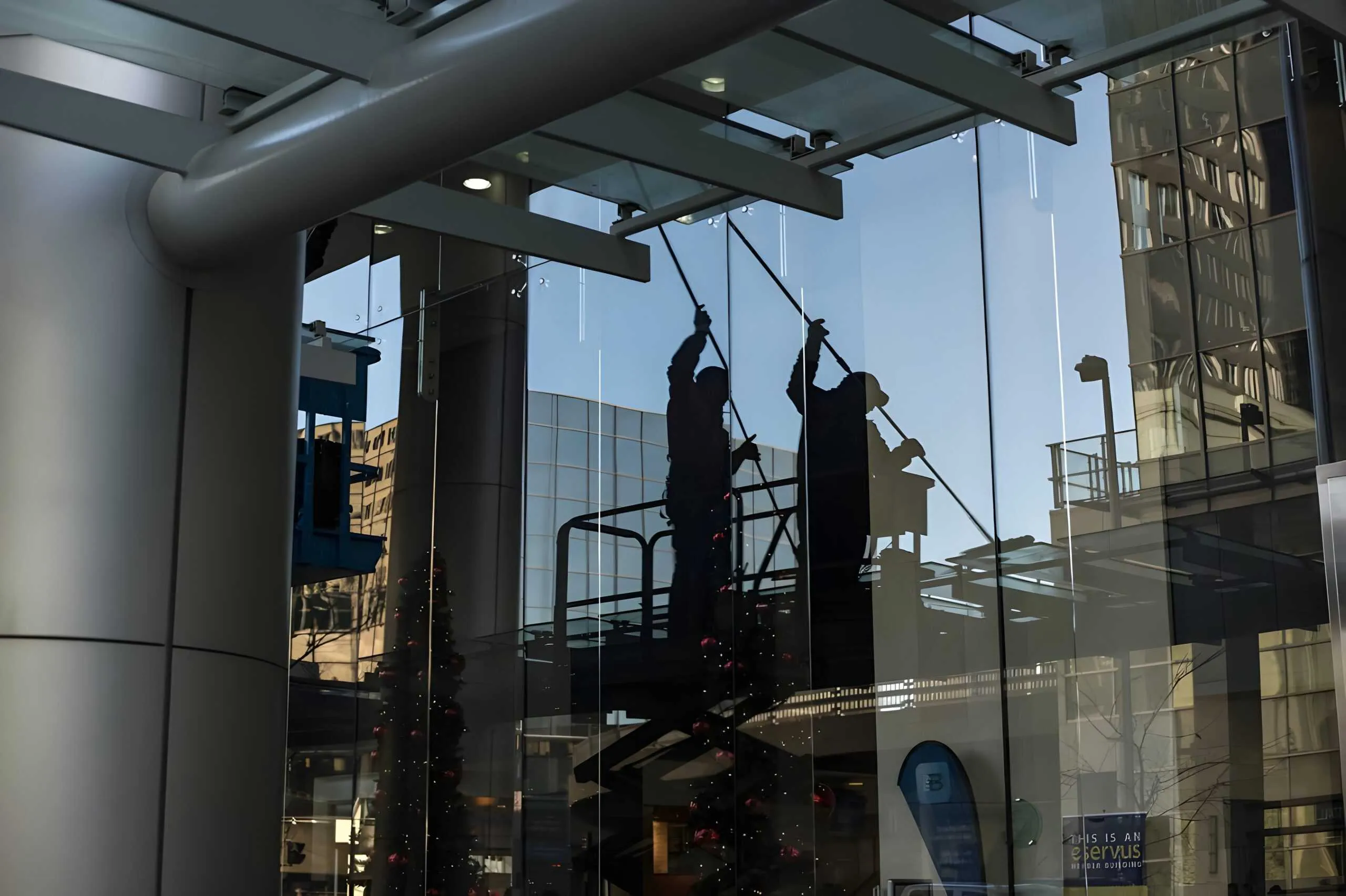 Window cleaners working on the glass front of a commercial building.