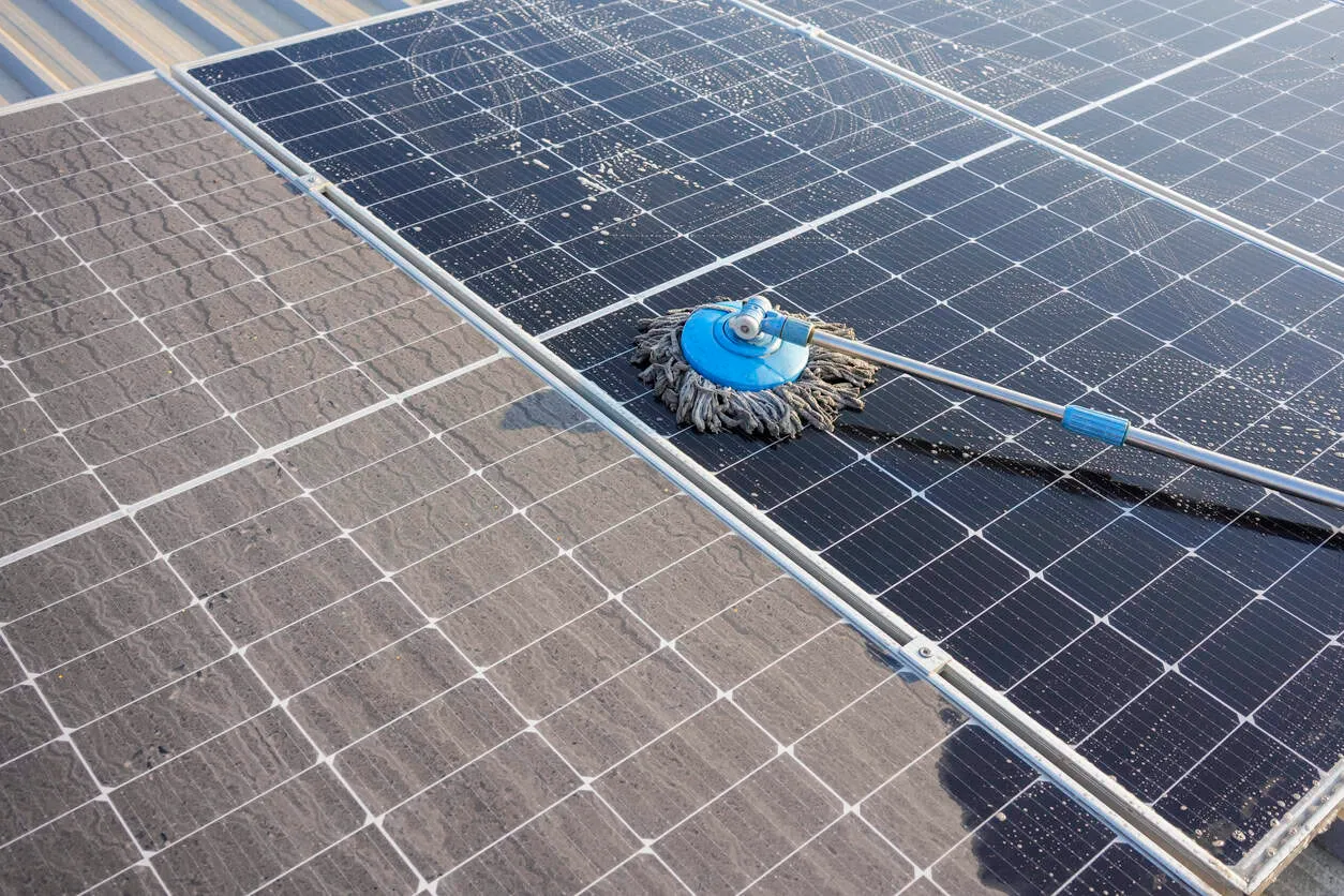 Professional solar panel cleaning service on rooftop solar panels.