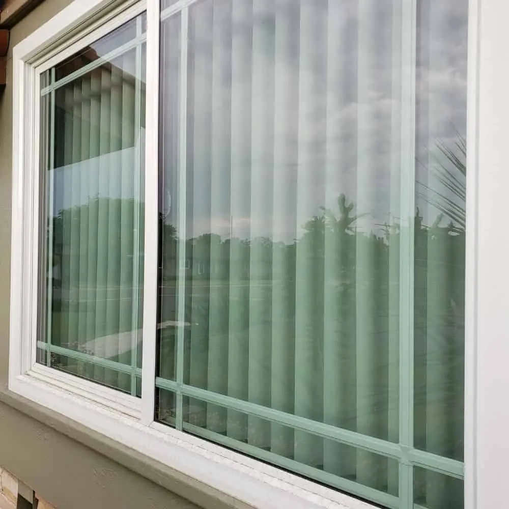 Professionally cleaned window with vertical blinds, showcasing streak-free clarity.